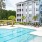a large building with a pool and trees in front of it