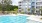 a large building with a pool and trees in front of it