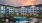 a large building with a pool and trees in front of it