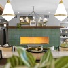 Spacious lounge with community fireplace with green backsplash 