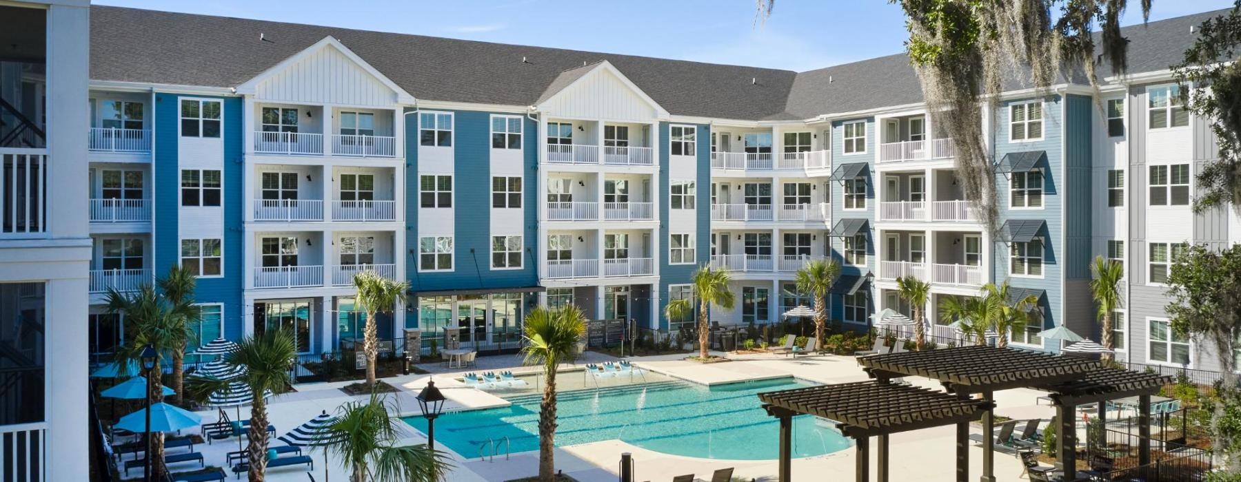 a large building with a pool and trees in front of it