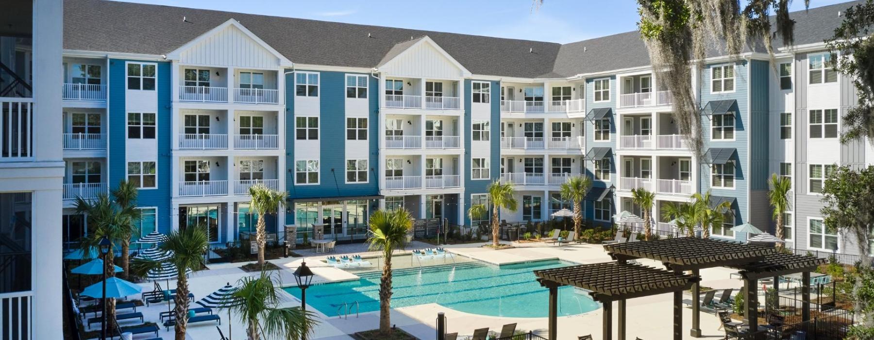 a large building with a pool and trees in front of it